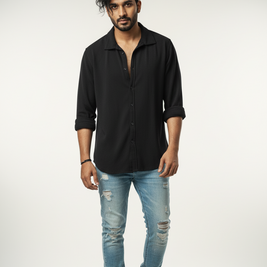 Man wearing a black shirt and light blue jeans on a white background